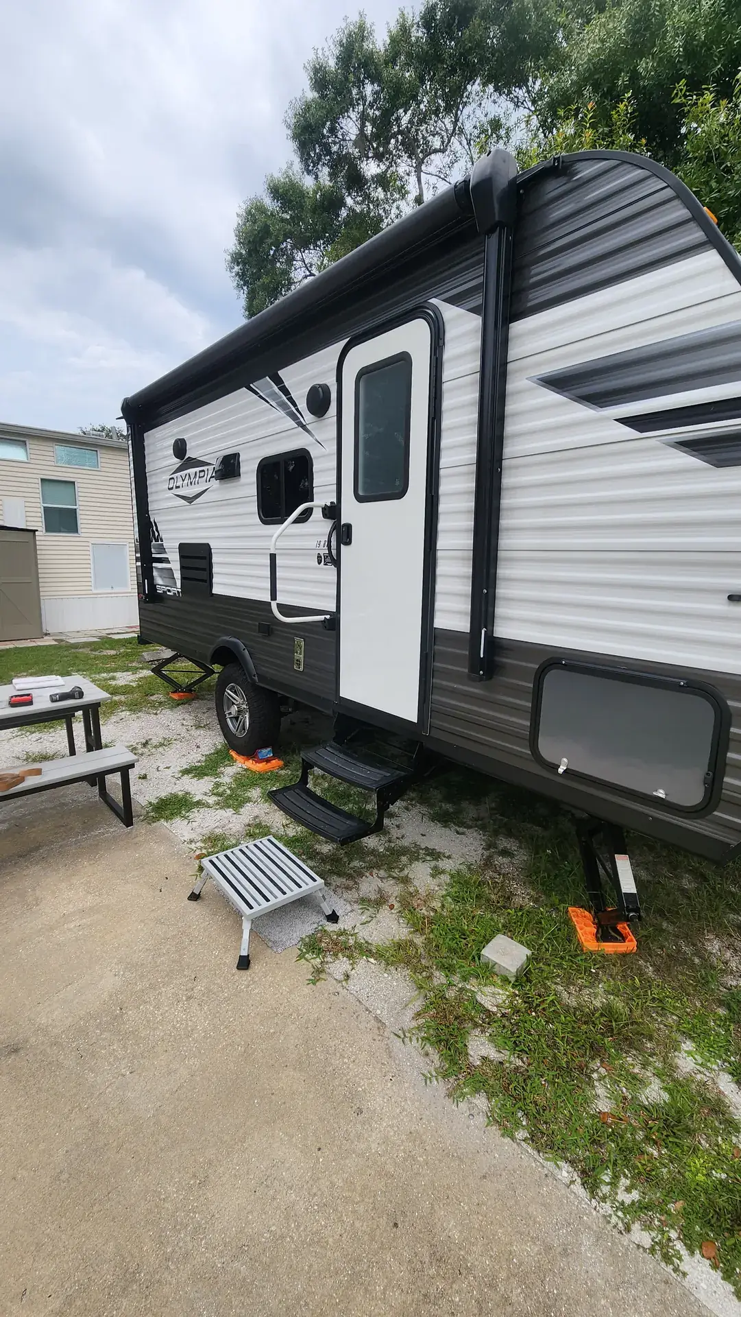Travel trailer leveled on jack pads with awning extended in Venice, Florida
