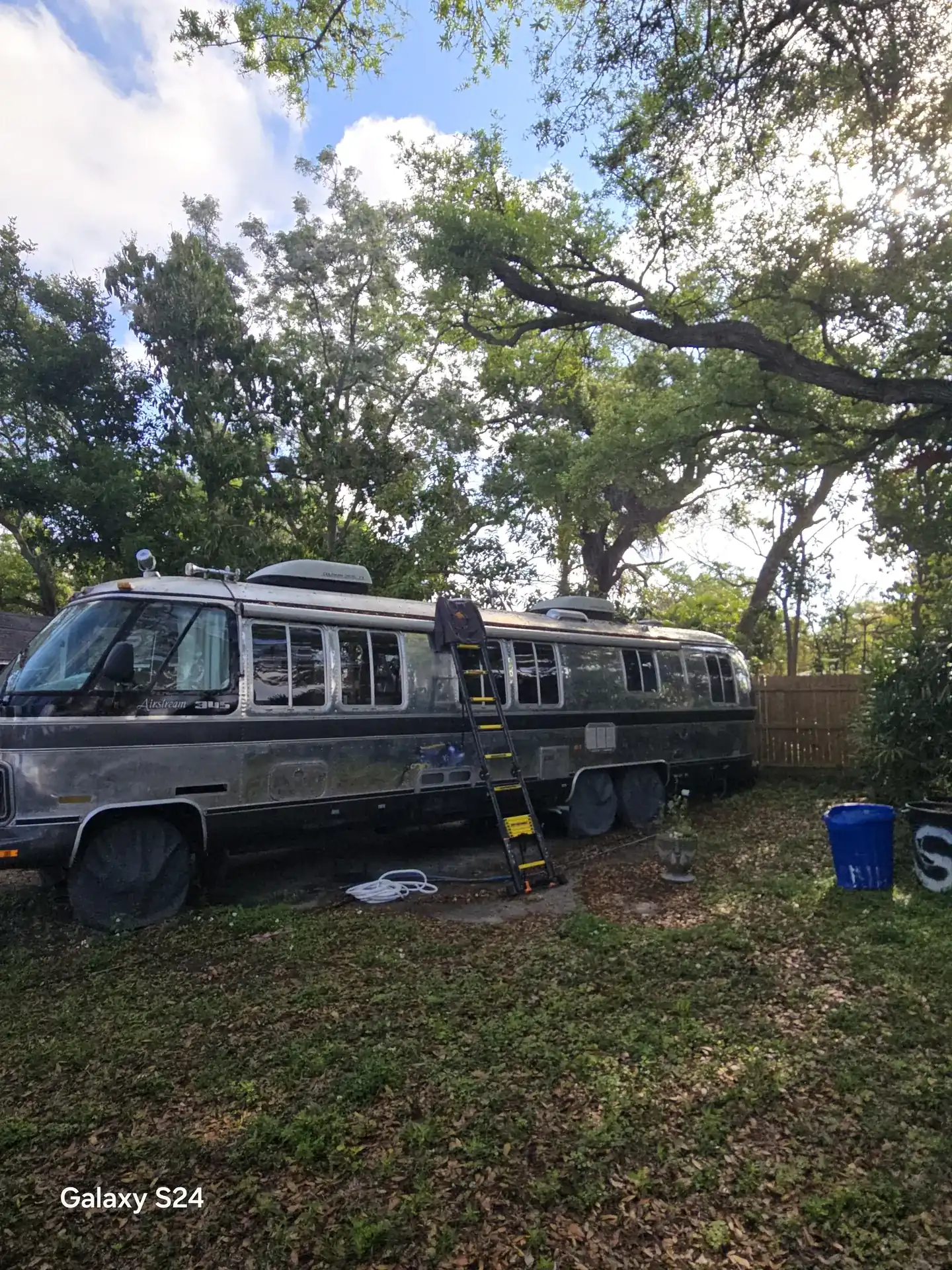 Ladder against a vintage Airstream motorhome during a roof repair in Bradenton, Florida